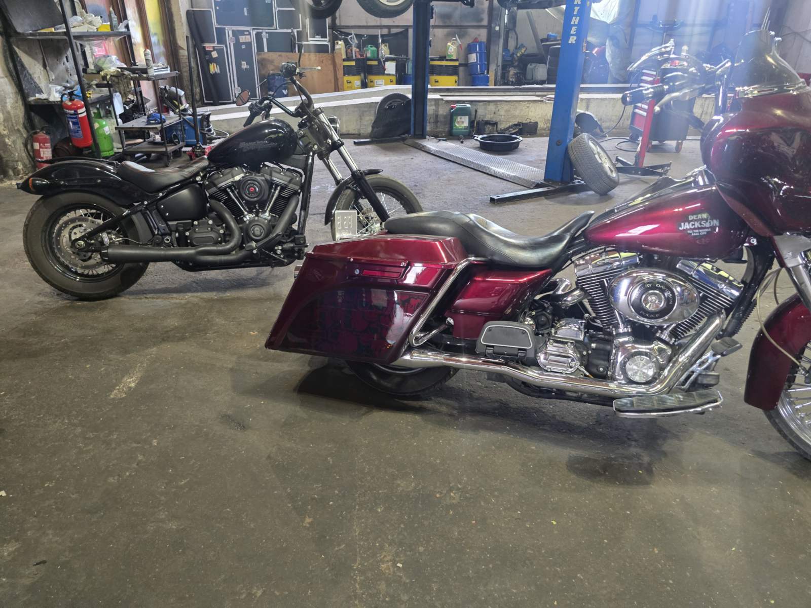 Два мотоциклета в сервизното хале — черен bobber и бордо Harley-Davidson
